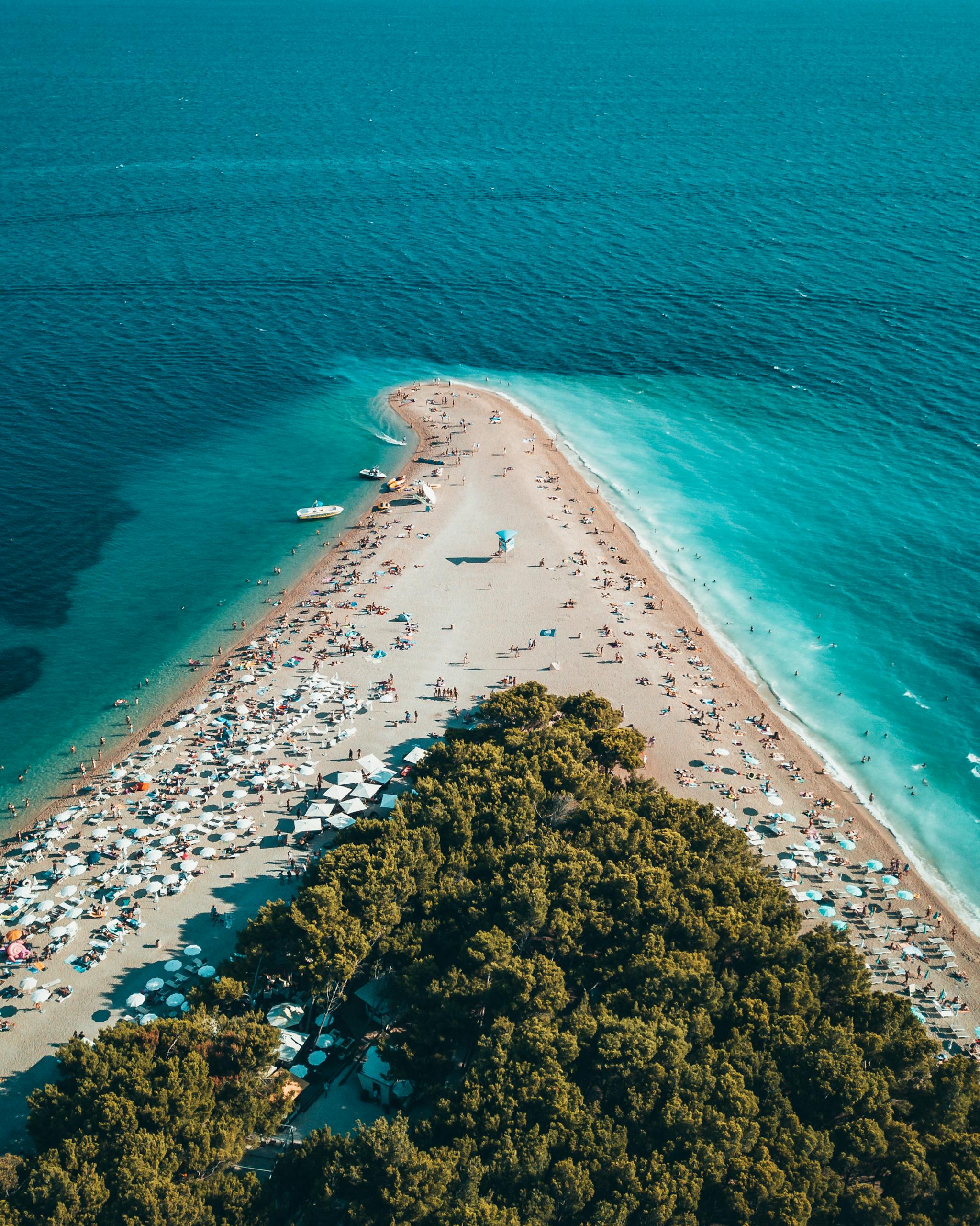 Stunning aerial view of Zlatni Rat beach in Bol, Croatia, showcasing turquoise waters and sandy peninsula.